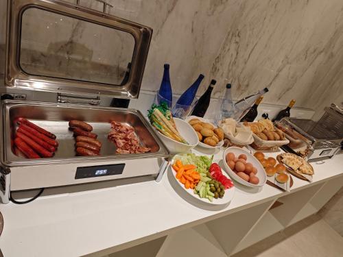 a buffet of food with sausage and vegetables on a table at Lh HOTELS in Milan