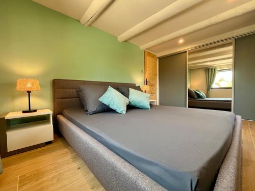 a bedroom with a large bed with blue pillows at Villa Opaline in Issirac