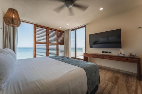 a bedroom with a large bed with a large flat screen tv at Casa Mori frente al mar in San Benito
