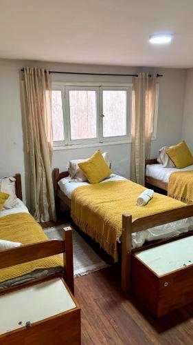 a bedroom with two beds and a window at BbCasita Blue in Santiago