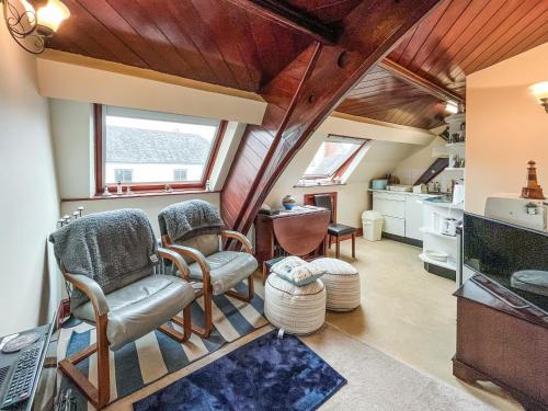 a living room with wooden ceilings and a large window at Chapel Court Loft Apartment in Beaumaris