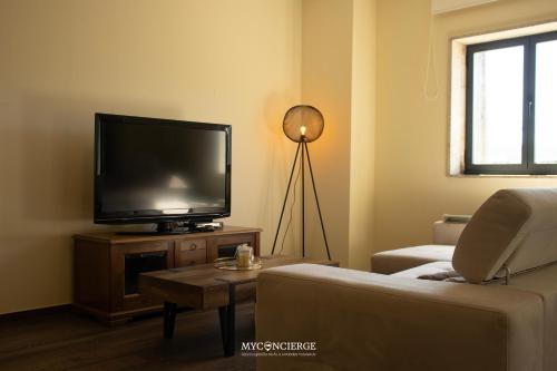 a living room with a flat screen tv and a couch at Casa da Portelinha in Castelo de Paiva