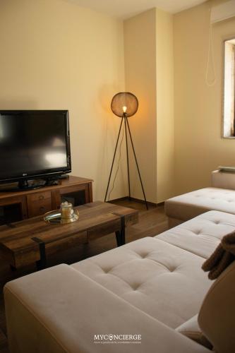 a living room with a flat screen tv and a table at Casa da Portelinha in Castelo de Paiva