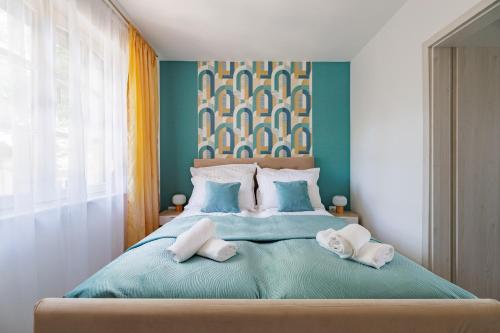 a bedroom with a large bed with two pillows at Deluxe Design Apartman in Debrecen