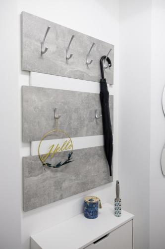 a wall with two hooks and an umbrella at Deluxe Design Apartman in Debrecen