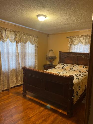 a bedroom with a large bed and two windows at Peace get away in Saint Albans