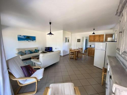 une cuisine et un salon avec un canapé et une table dans l'établissement Résidence 110-montalivet - Réf 110 - Jolie maison proche du marché de Montalivet et de ses plages MAE-7081, à Vendays-Montalivet