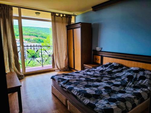 une chambre avec un lit et une grande fenêtre dans l'établissement ANDALUSIA BEACH A602 Elenite, à Bourgas