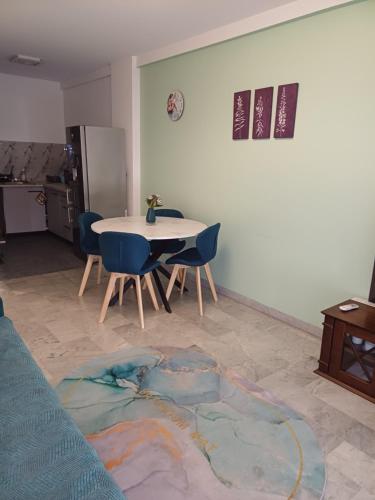 un salon avec une table et des chaises bleues dans l'établissement Charmant F1 près tramway et plage, à Nice