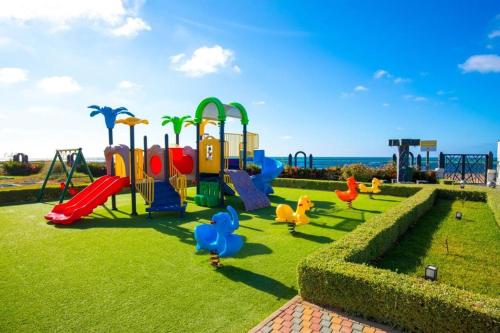 a park with a playground with ducks on the grass at Garden Bay Luxe, Tamaris Bord de Mer in Casablanca
