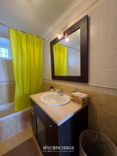 a bathroom with a sink and a green shower curtain at Casa do Canastro in Vale de Cambra