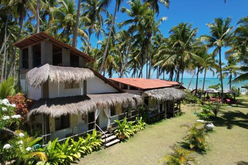 雅帕拉廷加Parador Algaroba的一座有棕榈树和大海的度假建筑