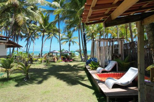 a porch of a resort with palm trees at Parador Algaroba in Japaratinga