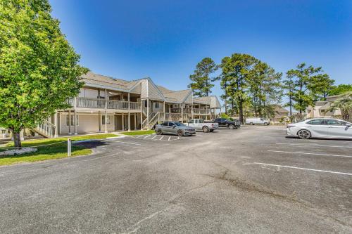 a parking lot with cars parked in front of a building at Little River Golf Retreat Less Than 5 Mi to Top Courses! in Little River