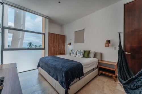 a bedroom with a bed and a large window at Navela 106 Depto vista al mar in Telchac Puerto