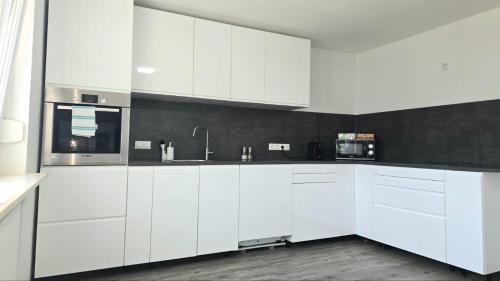 a white kitchen with white cabinets and a sink at HAPPY HOMES FUN - Up to 8 - Küche - W-LAN - Netflix - PS5 - Badewanne in Altenstadt