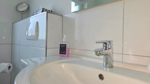 a bathroom sink with a soap dispenser on top of it at HAPPY HOMES FUN - Up to 8 - Küche - W-LAN - Netflix - PS5 - Badewanne in Altenstadt