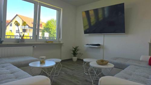 a living room with couches and a flat screen tv at HAPPY HOMES FUN - Up to 8 - Küche - W-LAN - Netflix - PS5 - Badewanne in Altenstadt