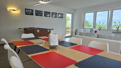 a dining room with a table with chairs and a couch at HAPPY HOMES FUN - Up to 8 - Küche - W-LAN - Netflix - PS5 - Badewanne in Altenstadt