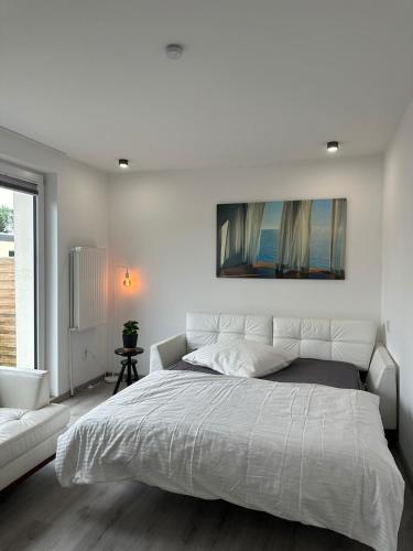 Un dormitorio blanco con una cama grande y un sofá. en Charming apartment near the airport, en Langenhagen