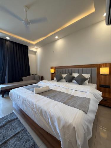 een slaapkamer met een groot wit bed en een bank bij Calestial Grand in Lucknow