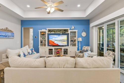 a living room with a white couch and a tv at Coastal Paradise Waterfront Pool Home in Bon Terra