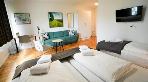 a living room with two beds and a couch at Hotel Nørherredhus in Nordborg