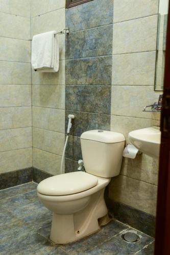 a bathroom with a toilet and a sink at Ocean Pearl Hotel in Karachi