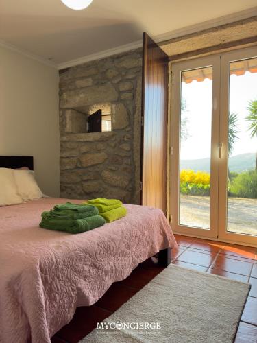 a bedroom with a bed with a stone wall at Casa do Canastro in Vale de Cambra