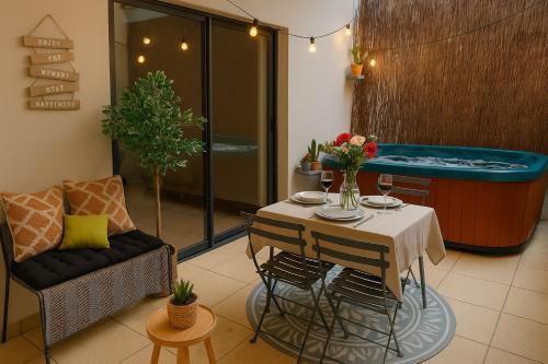 - un salon avec une table et une baignoire dans l'établissement Villa l'Eden de Camargue- Spa et Nature, à Candillargues