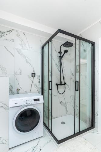 a washing machine in a bathroom with a shower at Ilir Apartman in Cres