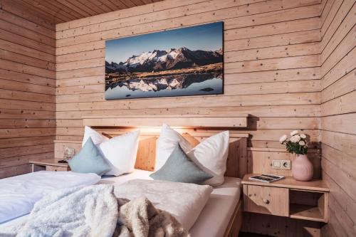 a room with a bed and a tv on a wall at Landhaus Rohrmoser in Zell am Ziller