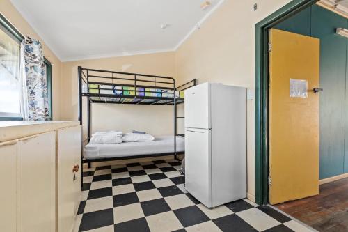 a kitchen with a refrigerator and a bunk bed at Mangoes Backpacker Hostel & Farmstay in Bowen