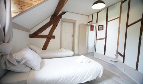 two beds in a room with windows at Le gîte du Canard boiteux in Silly