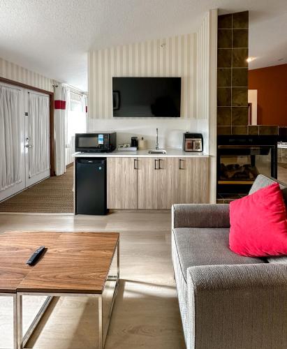 a living room with a couch and a flat screen tv at Prestige Prince George Lodge in Prince George