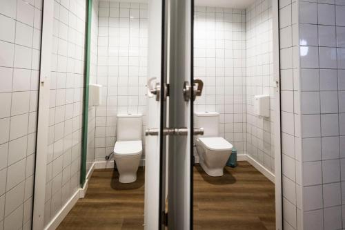 a bathroom with two toilets and two stalls at Hostel Charino in Pontevedra