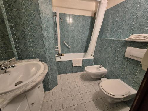 a bathroom with a sink and a toilet and a tub at Hôtel Val Du Tech in Prats-de-Mollo-la-Preste
