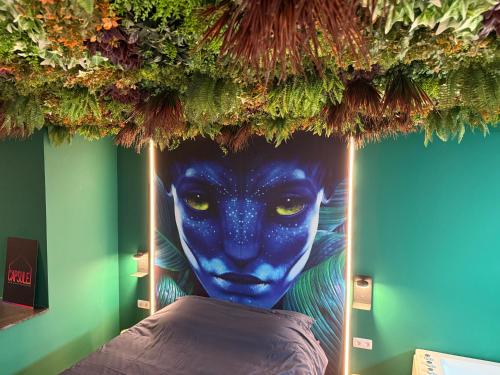 a painting of a blue face on a wall at Capsule Avatar - Balneo Sauna Projecteur Nintendo in Mons