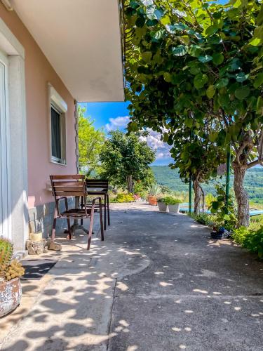 a porch with a bench and a table with a view at 4 Roses Residence in Sečovlje
