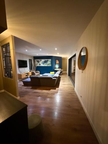 ein Wohnzimmer mit einer Couch und einem Spiegel in der Unterkunft Villa moderne avec piscine chauffée in Artigues-près-Bordeaux
