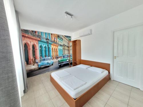 a bedroom with a bed and a painting of a street at Vila Toscana in Eforie Nord