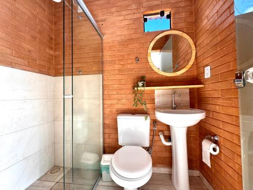 a bathroom with a toilet and a sink and a mirror at Fazenda Rosmaninho in Alto Paraíso de Goiás