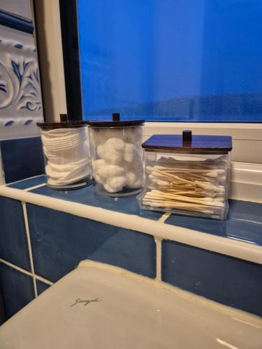 a shelf with two plastic containers of paper on it at Glandore Cliff Cottage Getaway - Sea Access with Private Pier in Glandore
