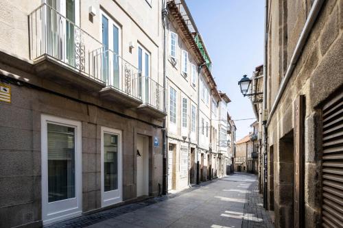an empty alley in a city with buildings at Hostel Charino in Pontevedra