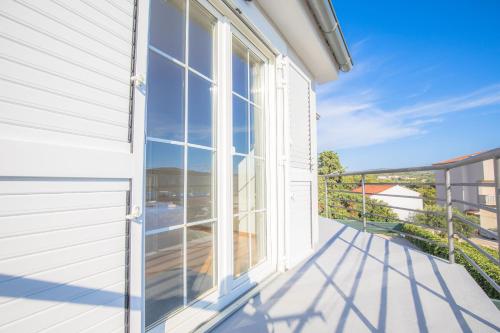 a white house with a large window on a balcony at House Matilda in Primošten