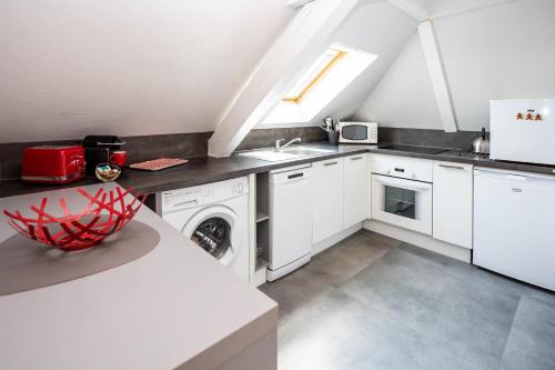 une cuisine blanche avec un évier et un lave-vaisselle dans l'établissement Le Balcon fleuri centre Robertsau tram Jardiniers, à Strasbourg