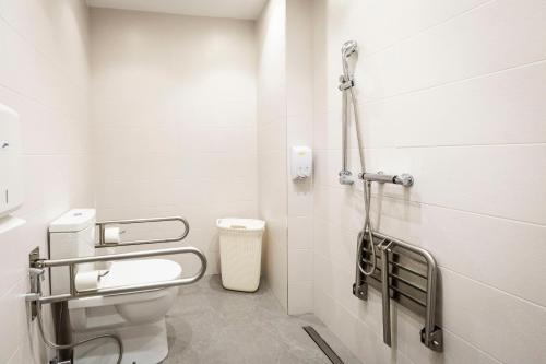 a white bathroom with a toilet and a sink at Hostel Charino in Pontevedra