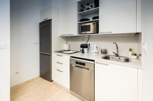 a small kitchen with a sink and a refrigerator at Hostel Charino in Pontevedra