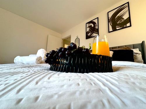 a plate of grapes and a glass of orange juice on a bed at Beautiful Spacious Kingsize Room Near Oval Station in London