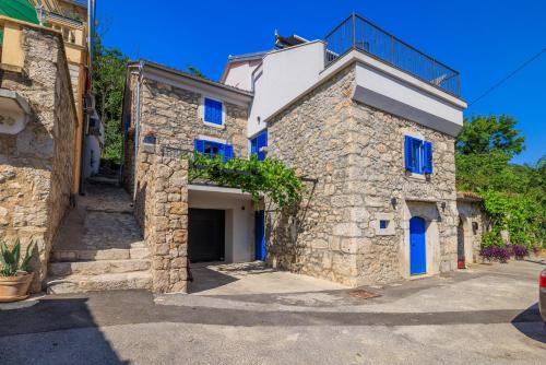a stone house with blue doors on a building at House Maris in Tribalj